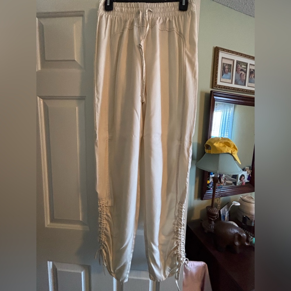 Like new cream colored silky dress pants with leg/ankle detail. Size Medium.